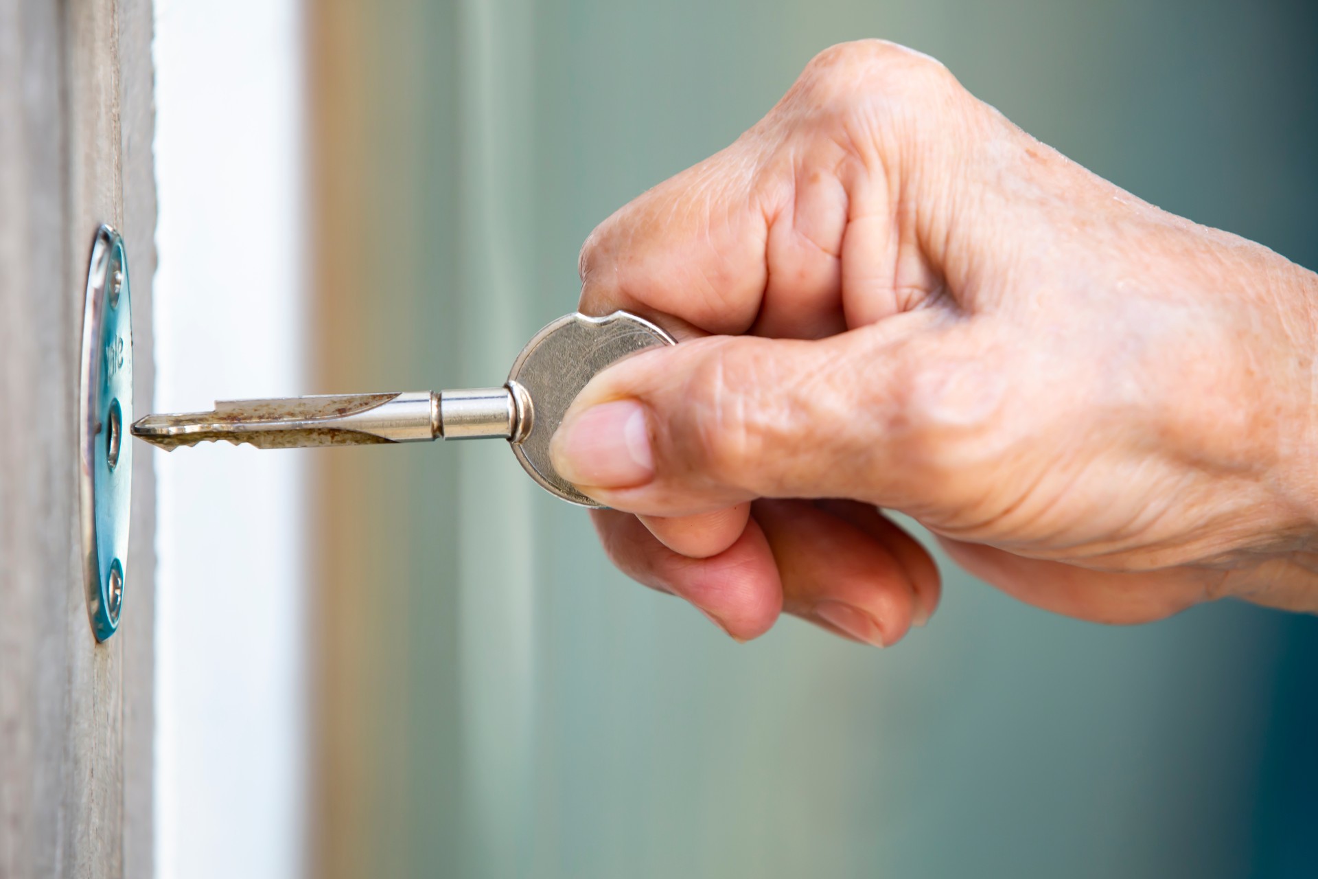 Senior woman's hand locking a door