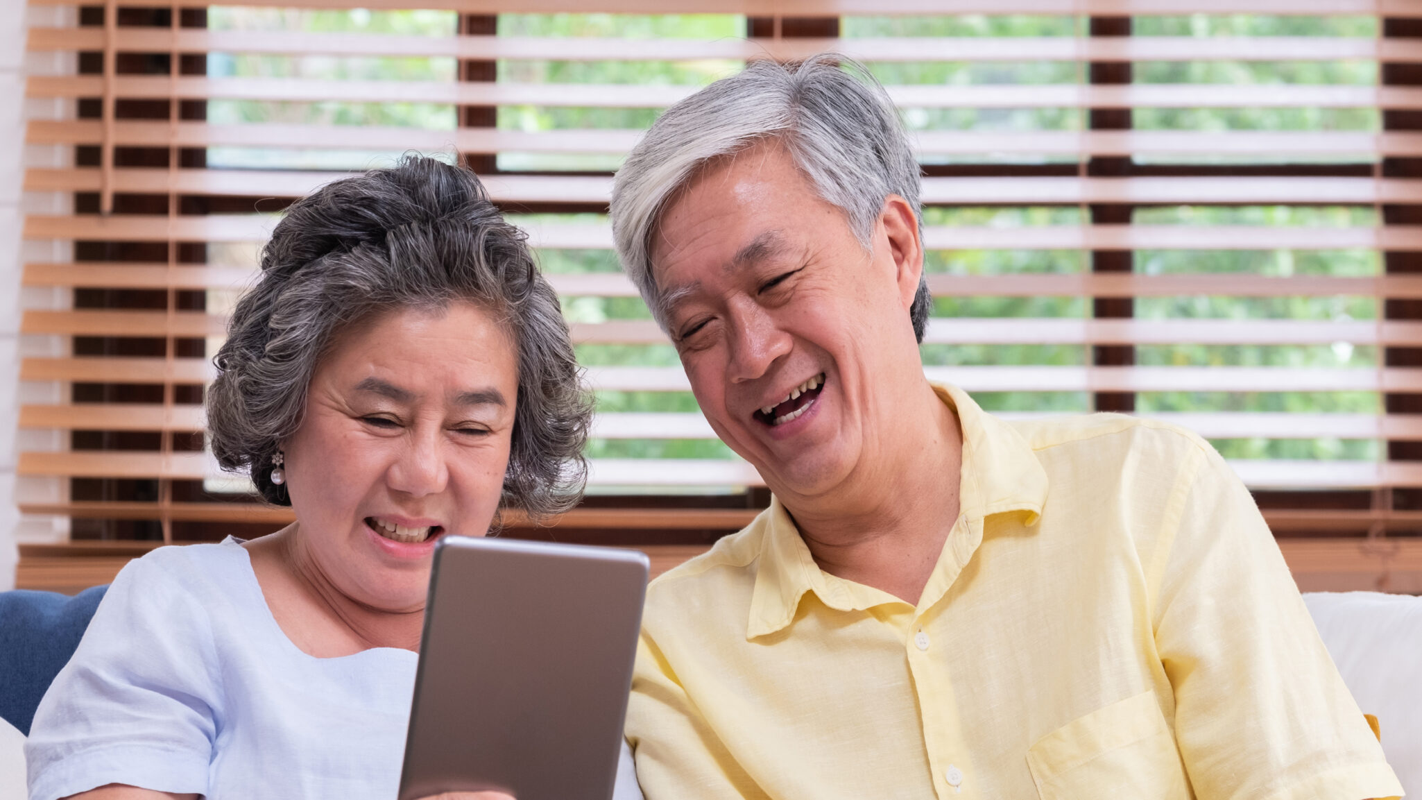 a senior couple researching senior living options on their tablet