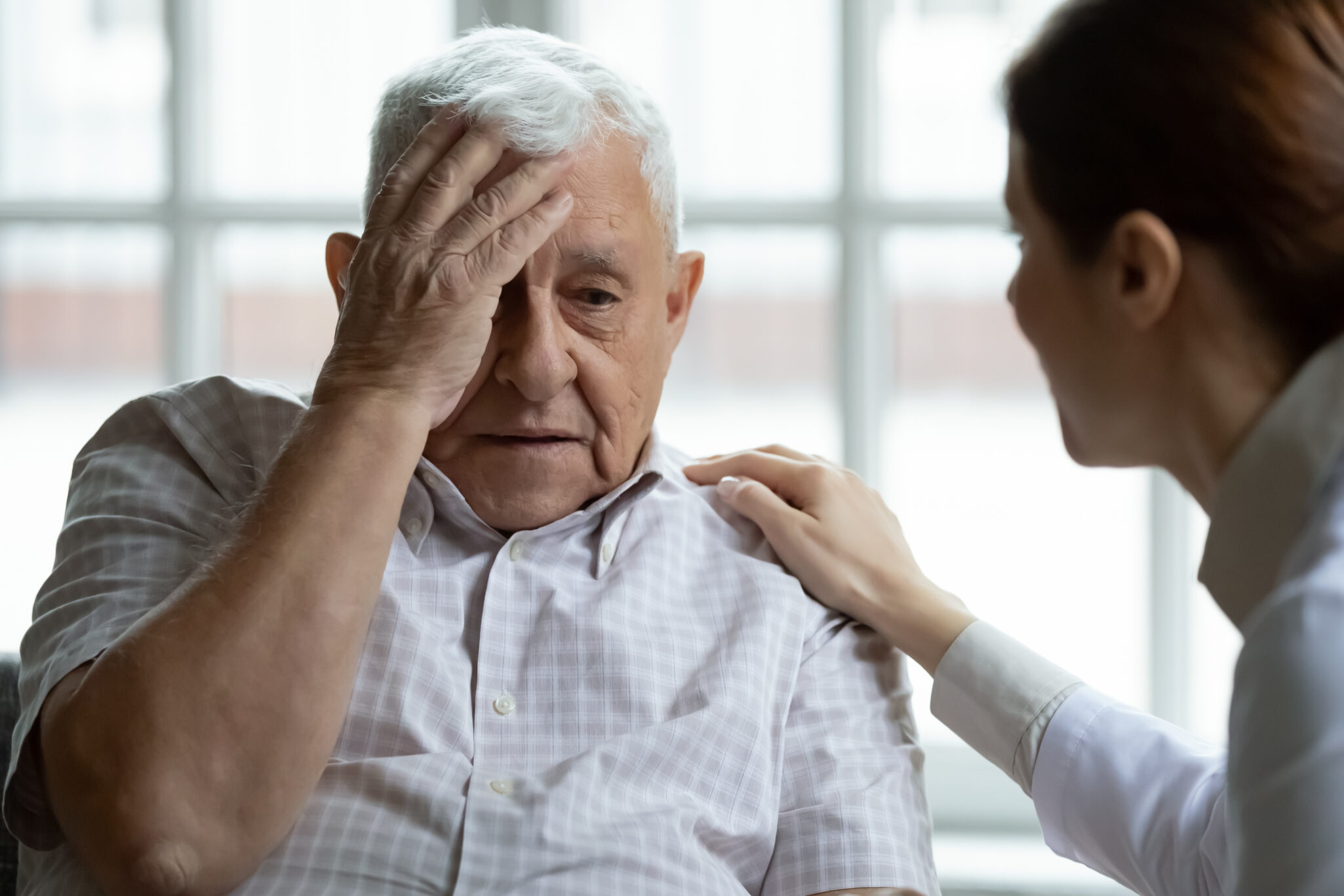 Senior man stressed and confused while doctor attends to him