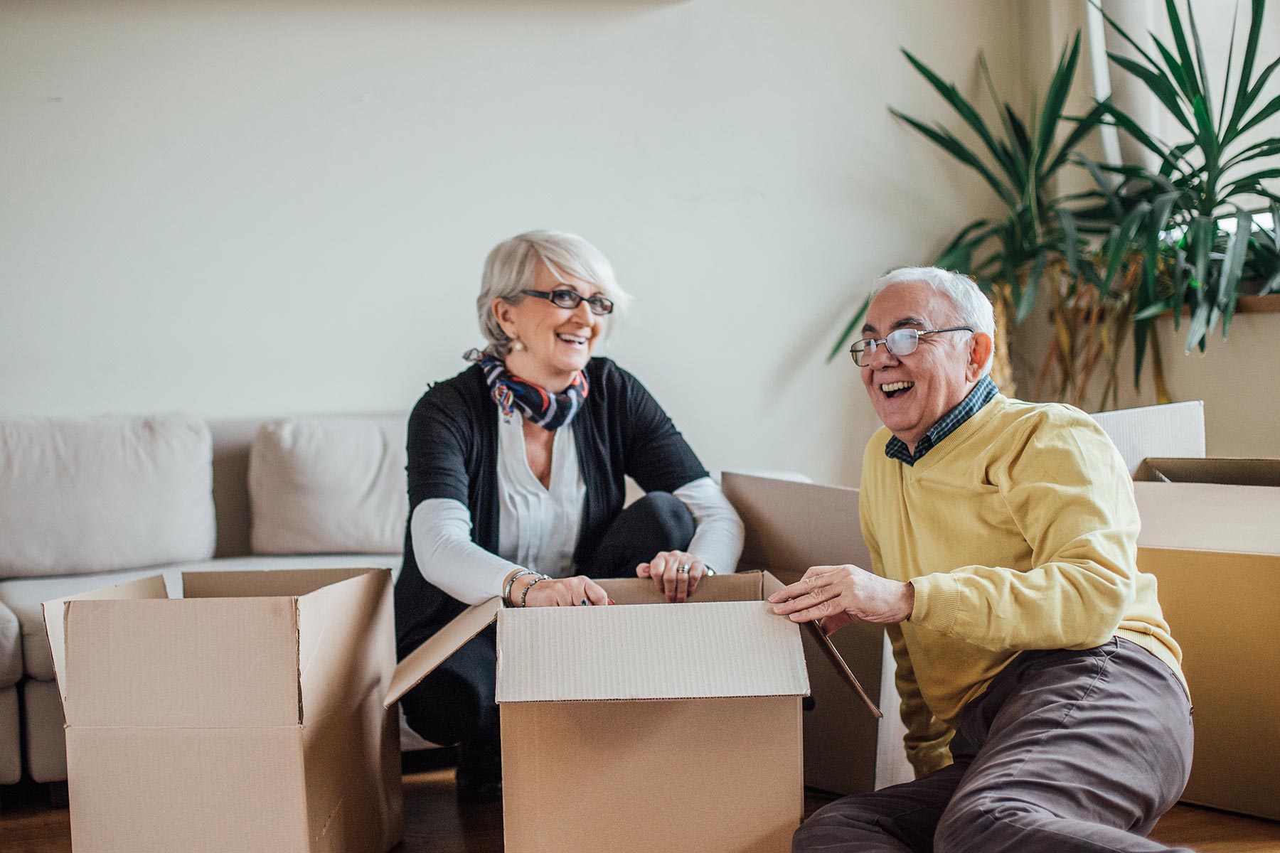 senior couple packing things in boxes to move
