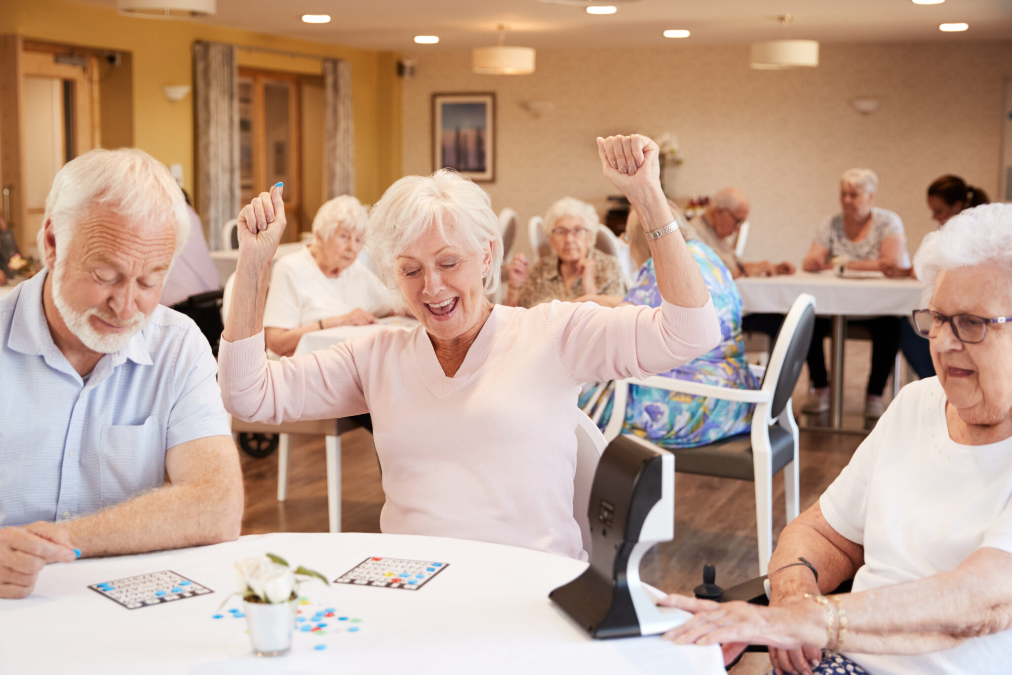 Senior excited at table while playing bingo