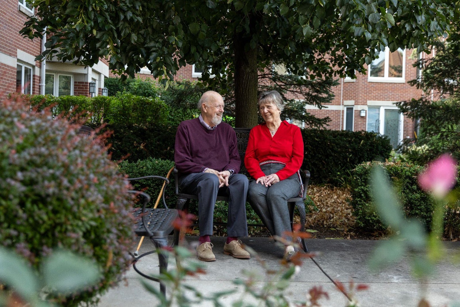 Resident couple sitting outdoors on a bench at Lake Forest Place