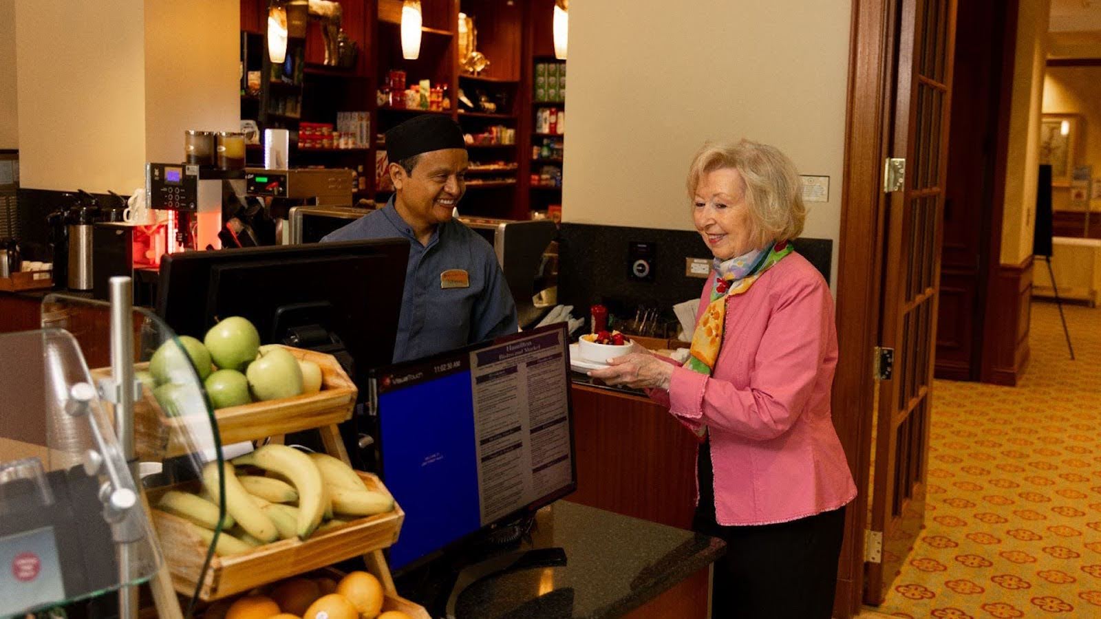 Resident of Lake Forest Place choosing a healthy snack at the bistro
