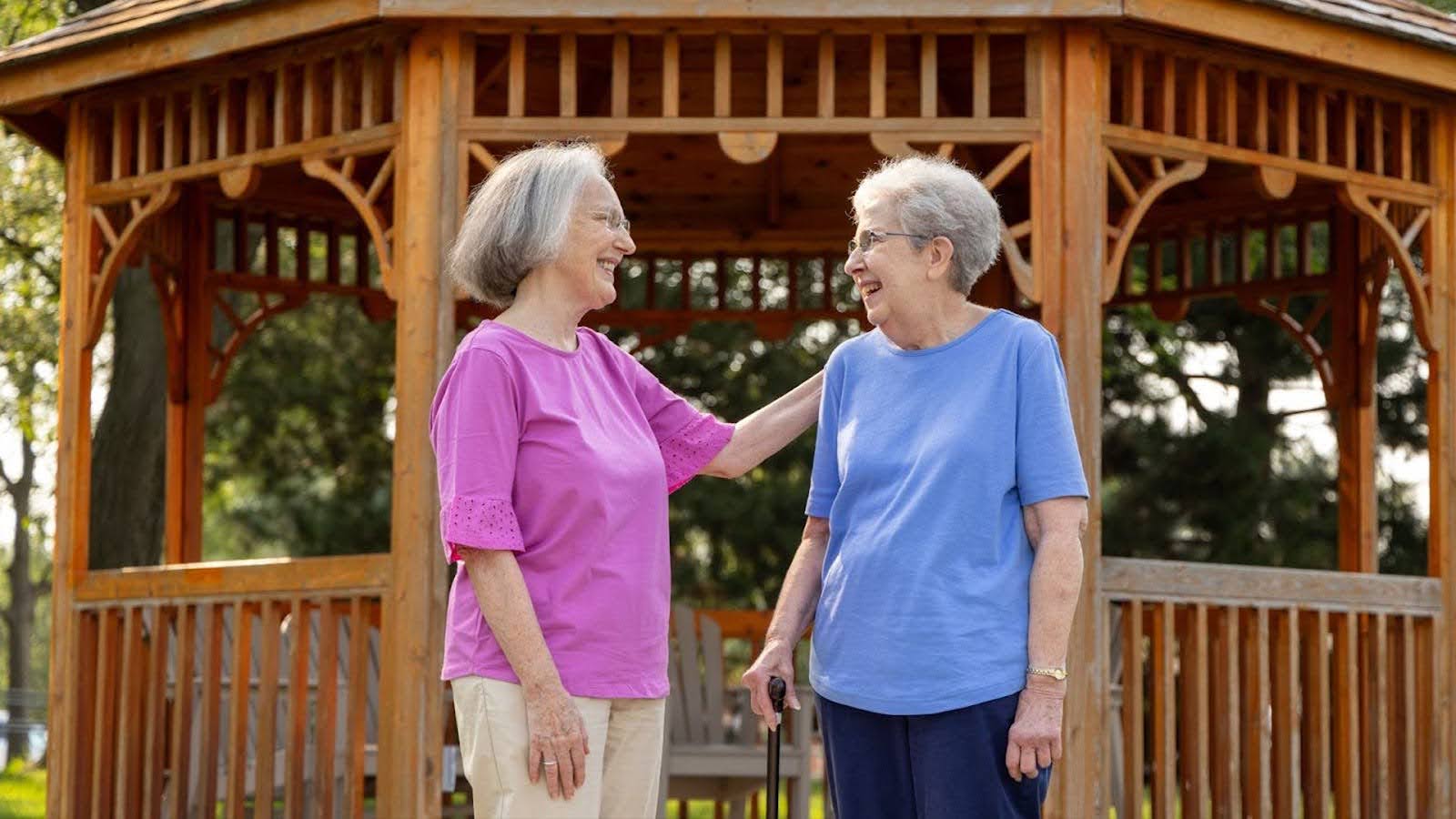 2 senior women talking by a gazebo at The Moorings of Arlington Heights