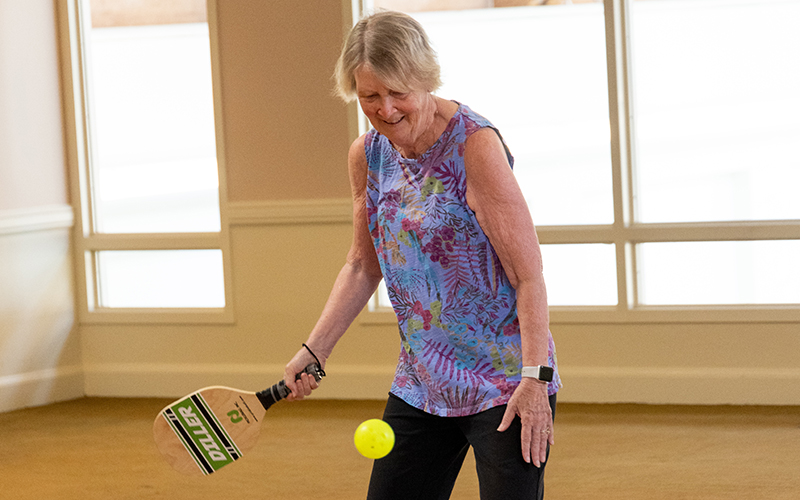 Senior woman playing paddle ball at Westminster Place