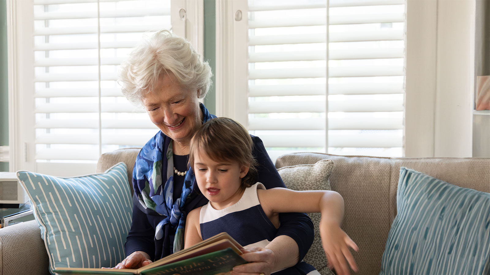 Resident reading a book with her granddaughter at Lake Forest Place