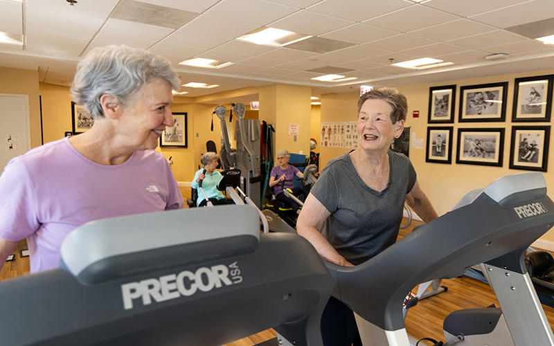 Two senior women working out on treadmills at Lake Forest Place
