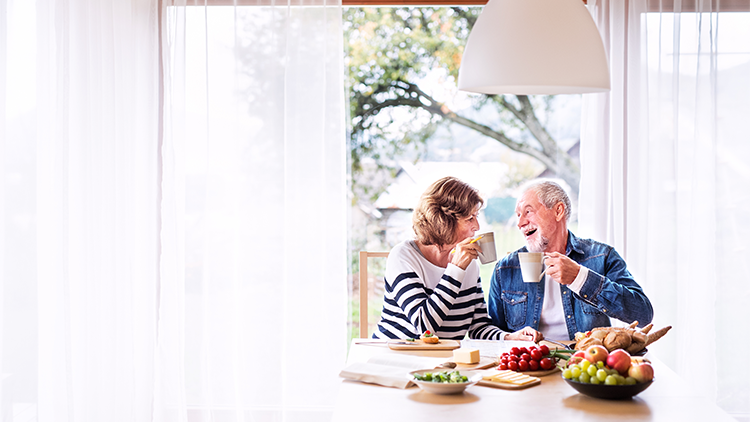 a senior couple enjoying breakfast and cups of coffee