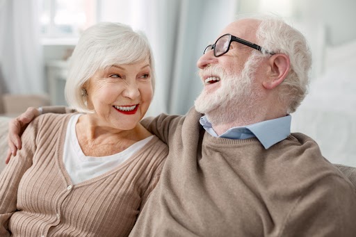 senior couple laughing together on the couch