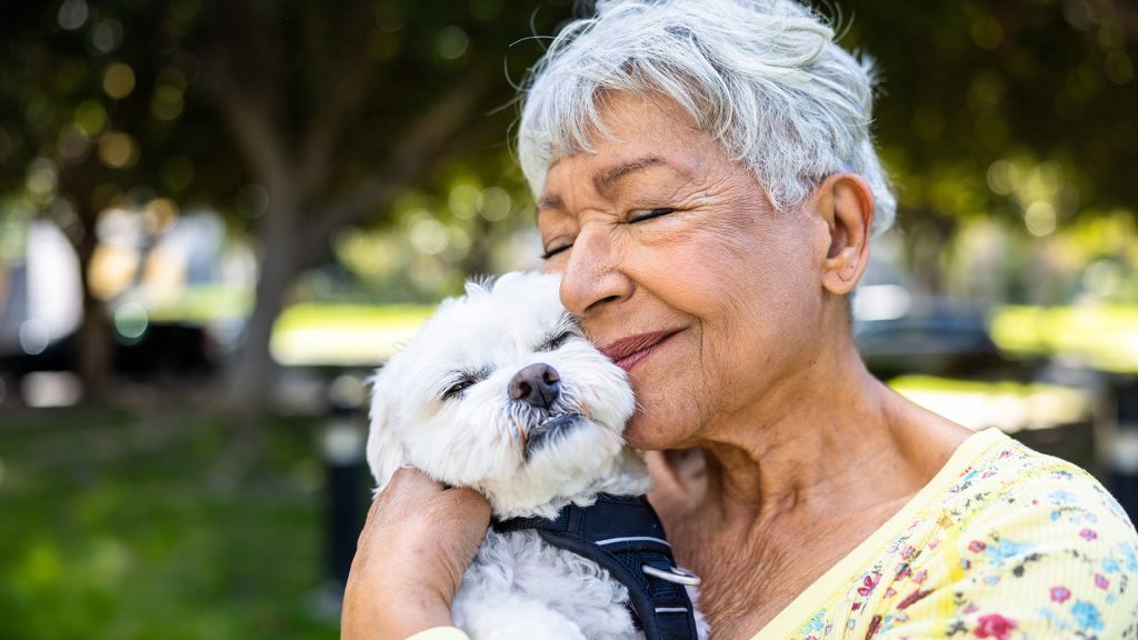 senior woman snuggling with her dog